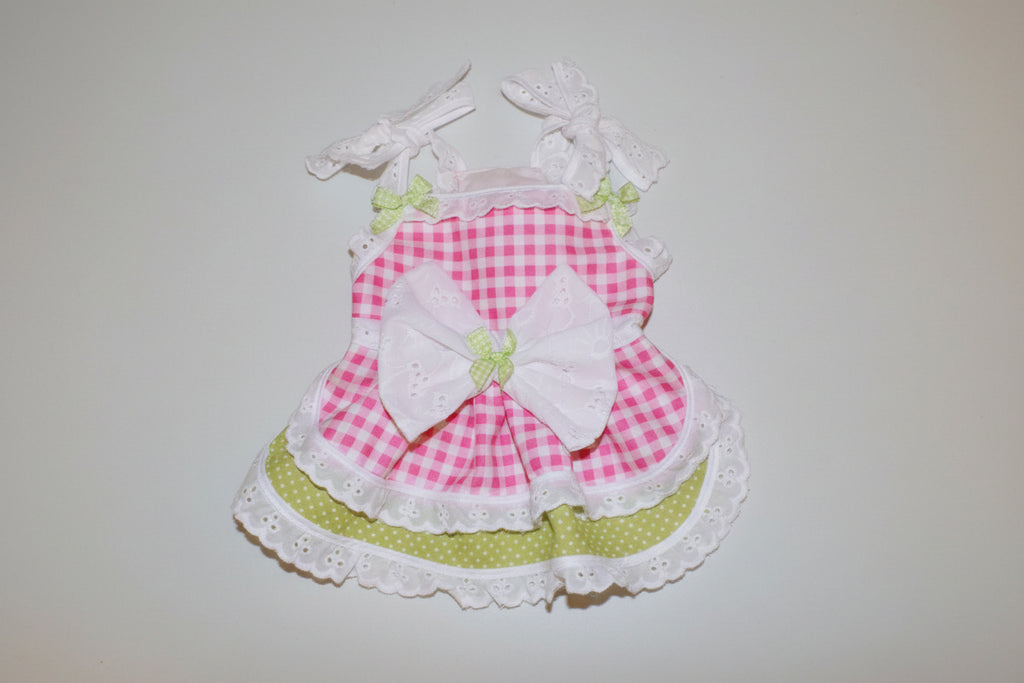 Pink checkered dress with a large white bow on a beige background