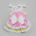 Pink checkered dress with a large white bow on a beige background