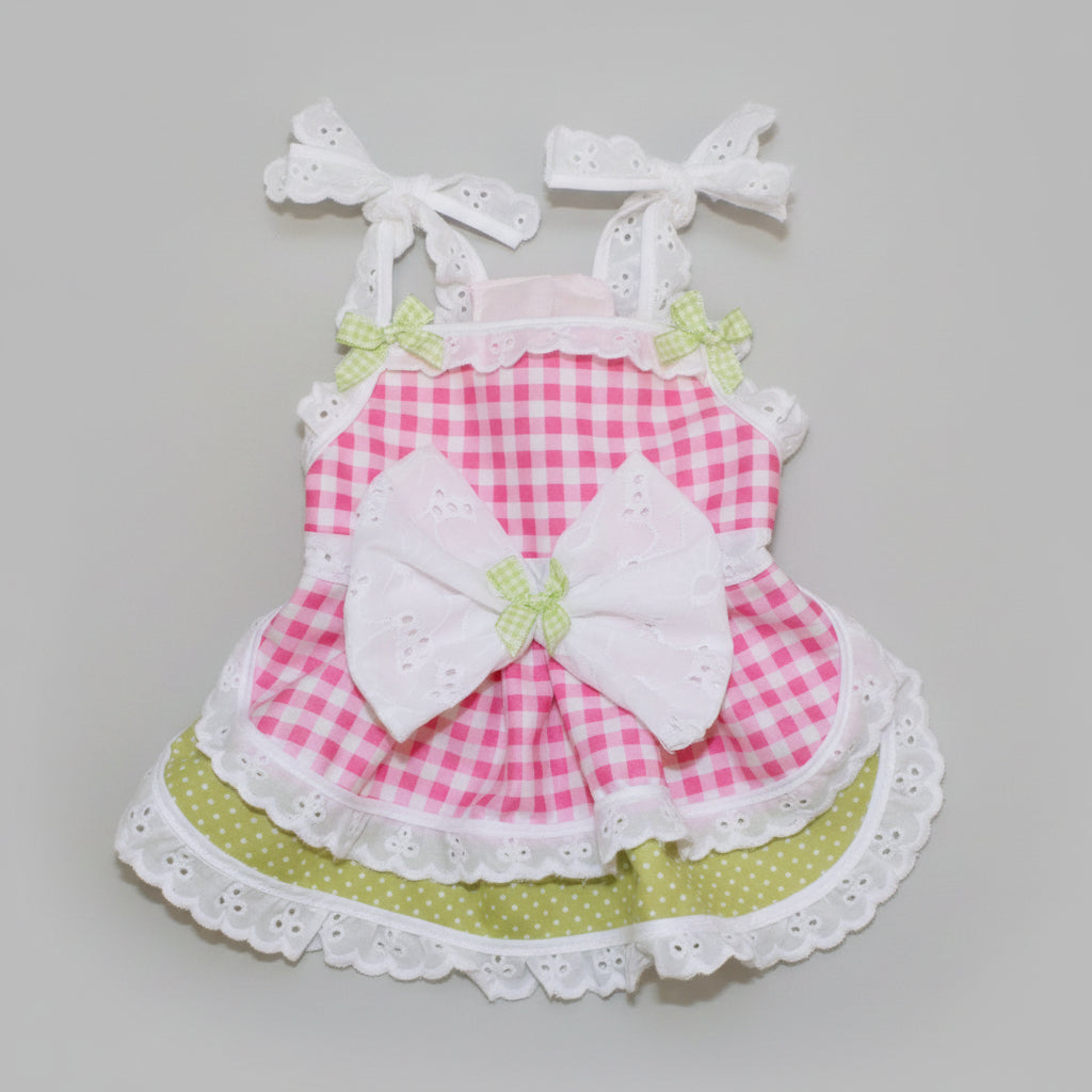 Pink checkered dress with a large white bow on a beige background