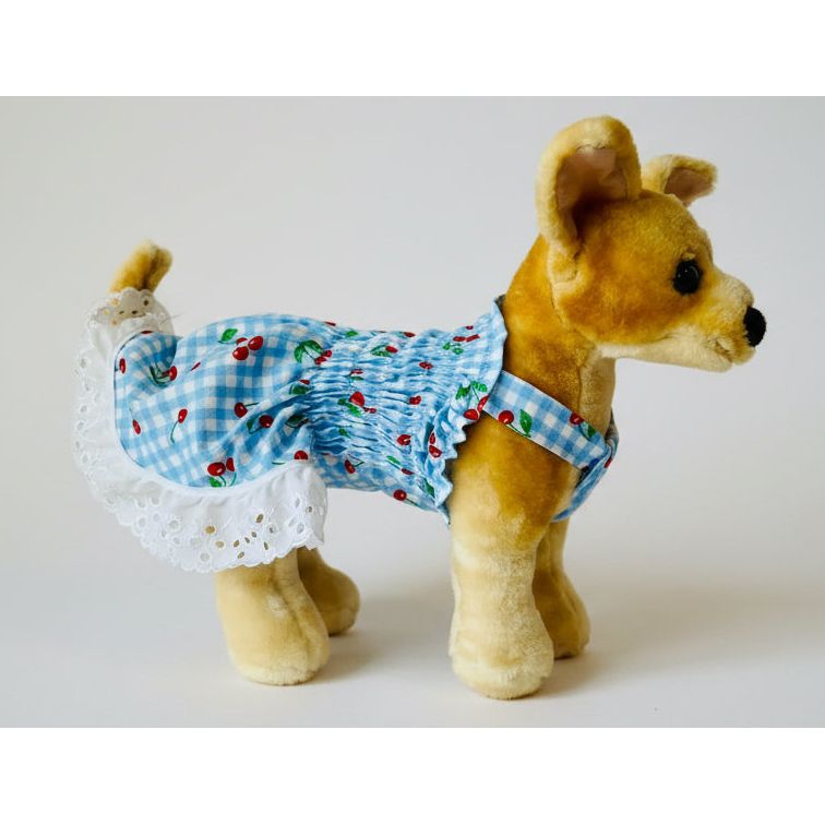 Stuffed dog toy wearing a blue checkered outfit with white trim on a white background