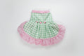 Green checkered pet dress with pink ruffle on a white background