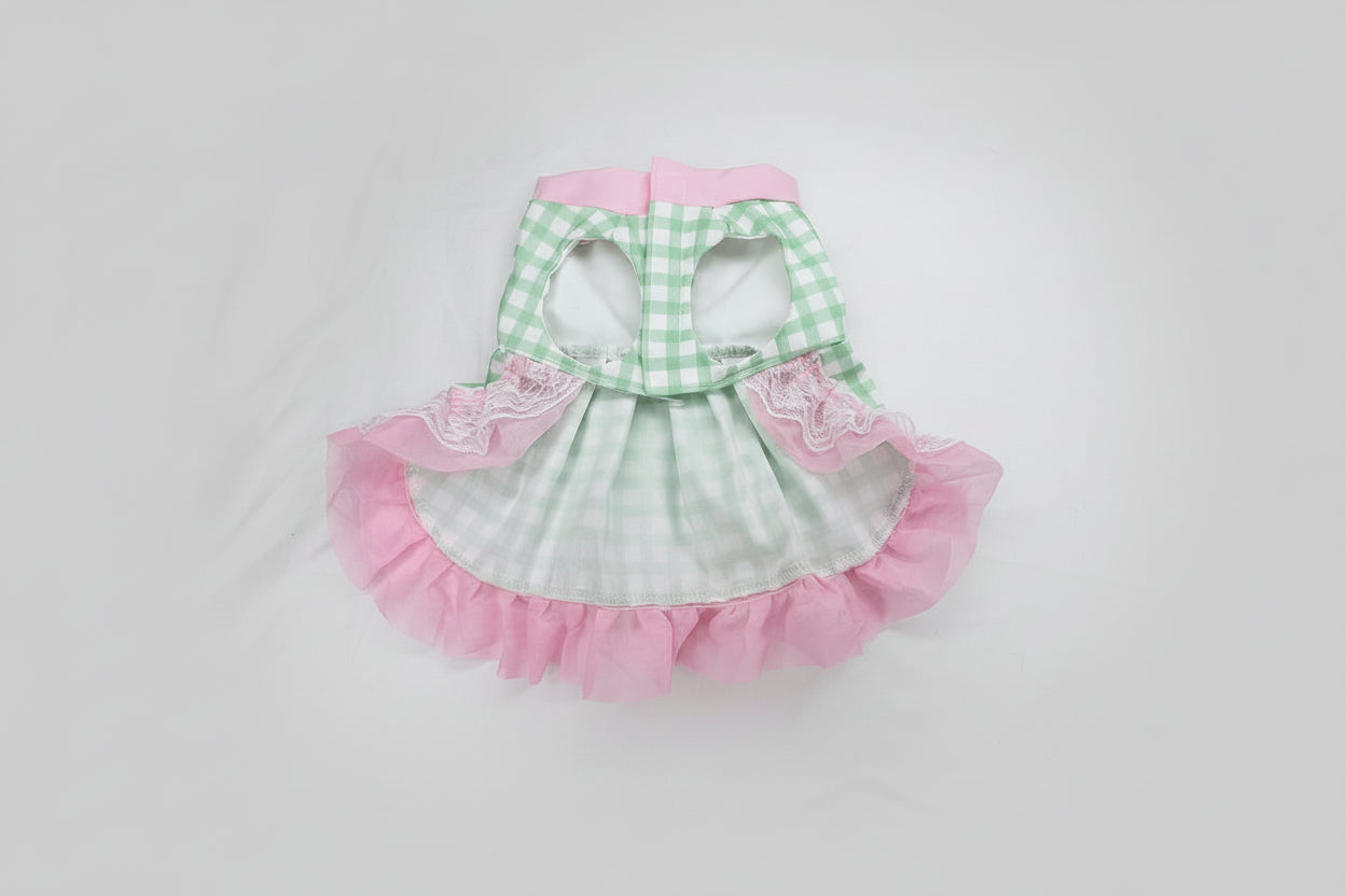 dog dress with pink ruffles and green checkered patterns on a white background
