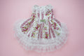 Floral dog dress with lace details on a pink surface