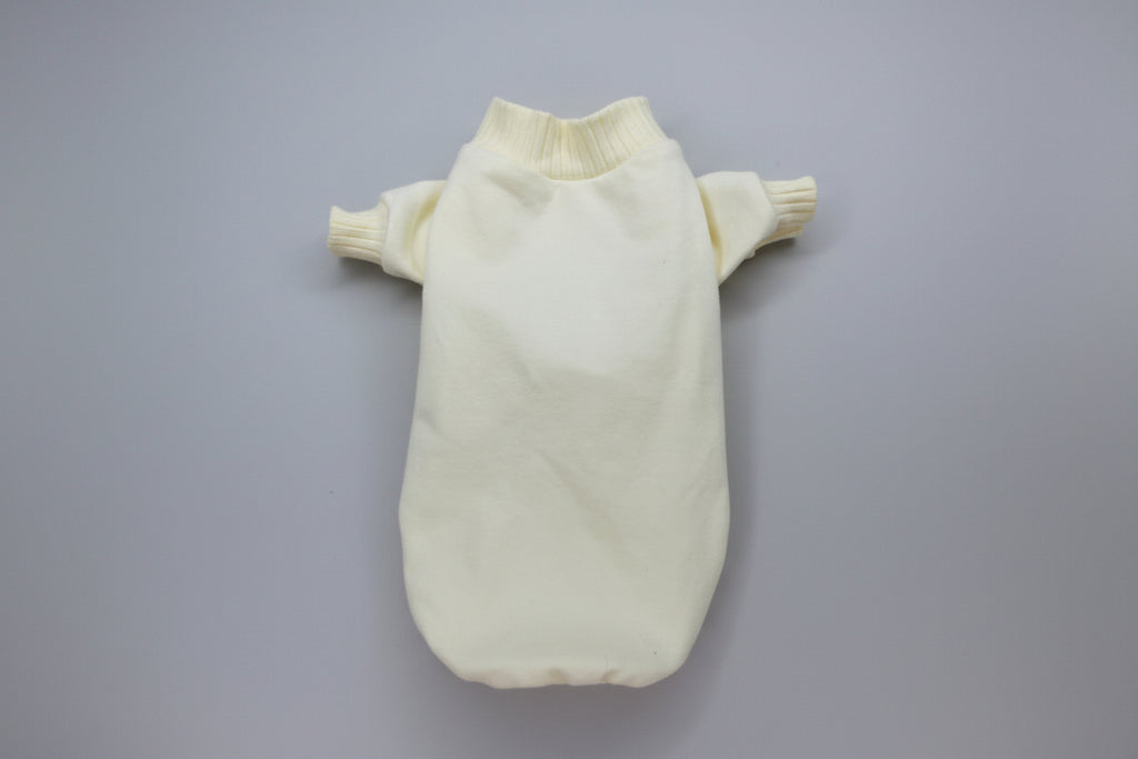 Cream-colored knitted dog sweater on a white background