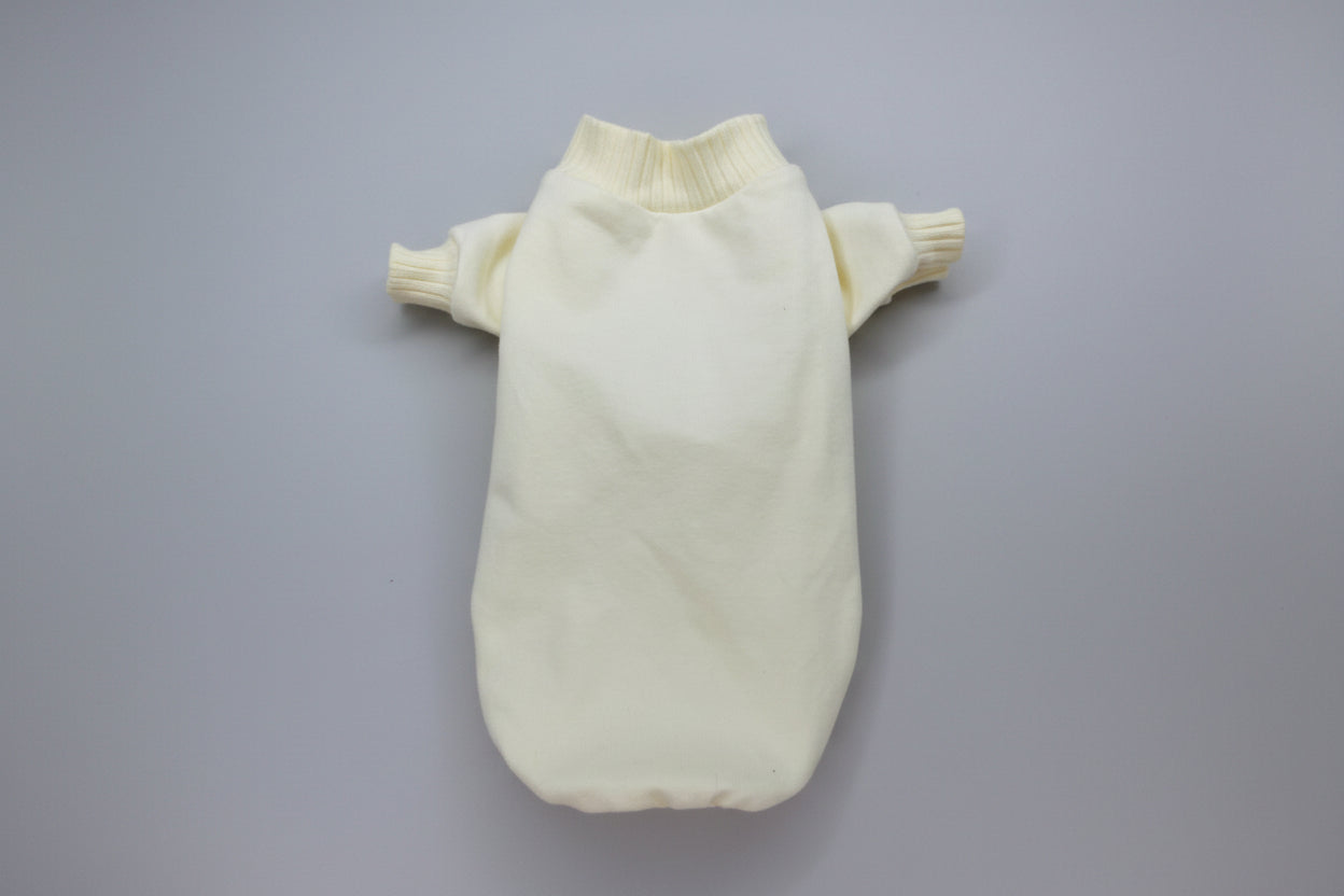 Cream-colored knitted dog sweater on a white background