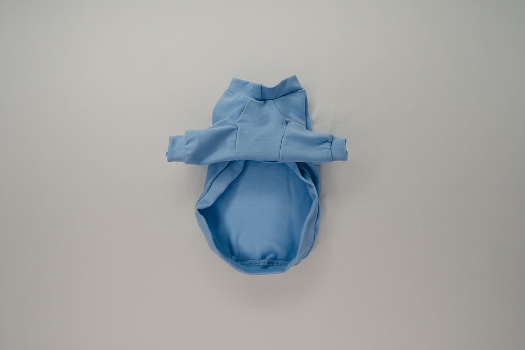 Blue dog shirt on a white bed