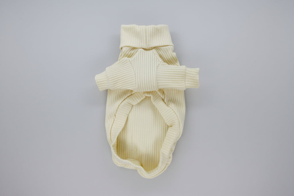 Cream-colored ribbed knit dog sweater on a white background