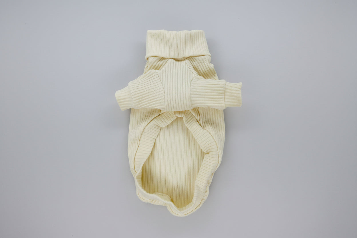 Cream-colored ribbed knit dog sweater on a white background
