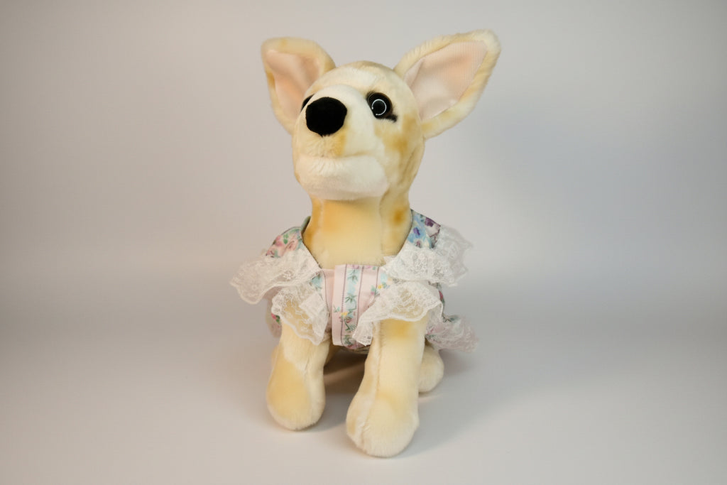 Plush dog toy with a dress on a pink background