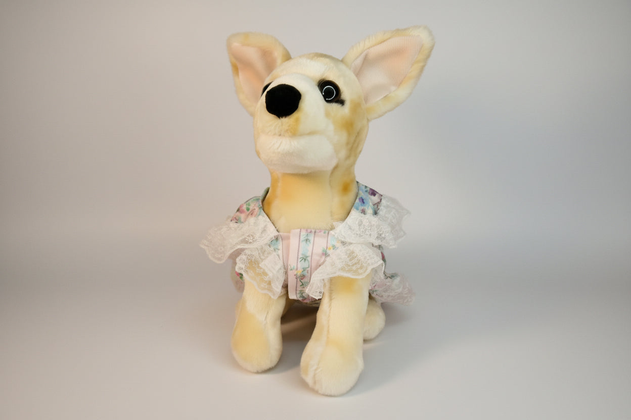 Plush dog toy with a dress on a pink background