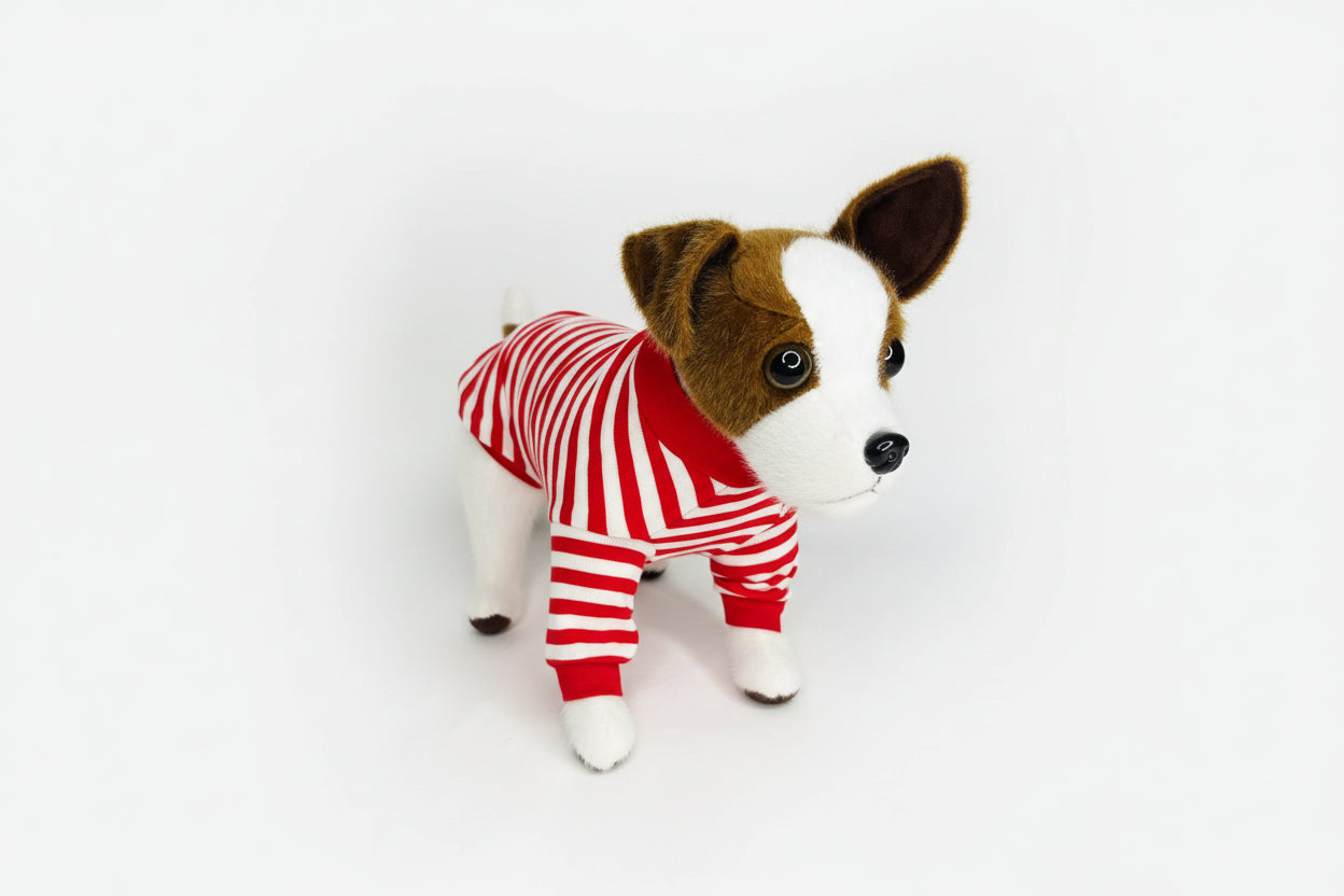 Stuffed dog toy wearing a red and white striped outfit on a white background