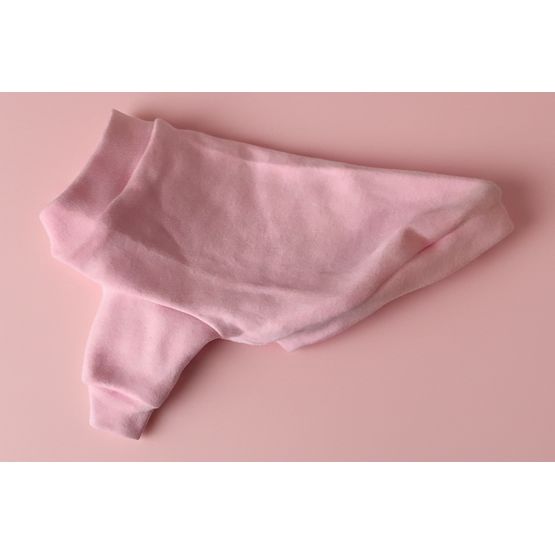 Pink dog shirt on a light-colored fabric surface