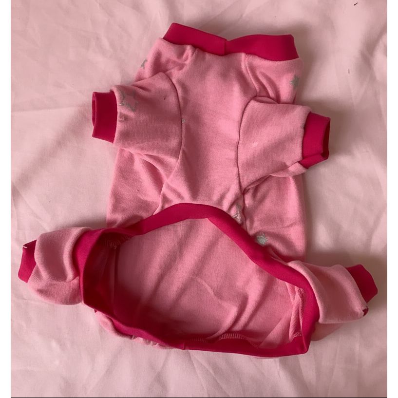 Pink dog pajamas with fuchsia trim on a pink background