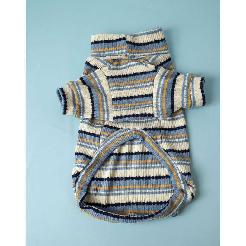 Knitted baby outfit with striped pattern on a white surface