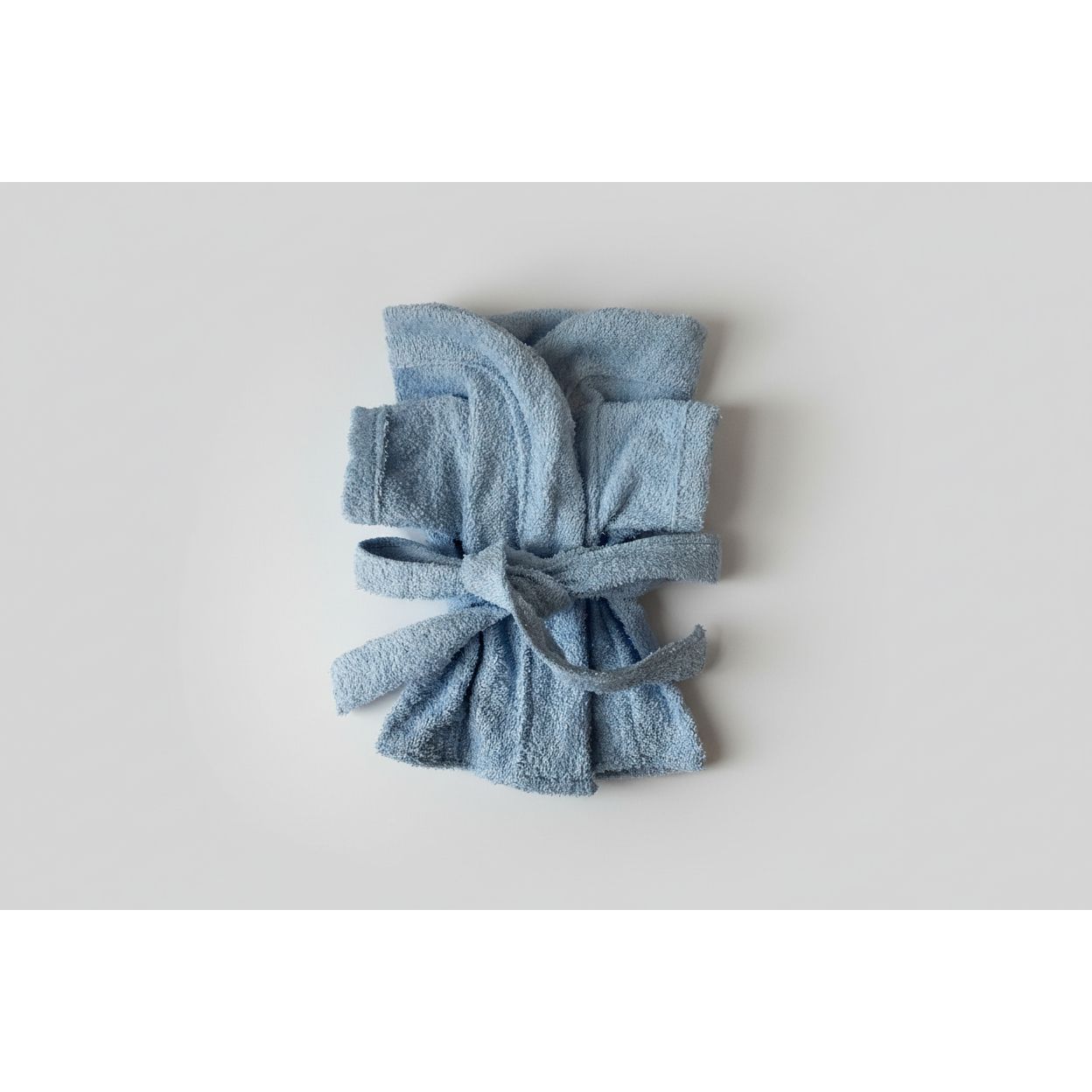 Blue robe folded on a light-colored surface
