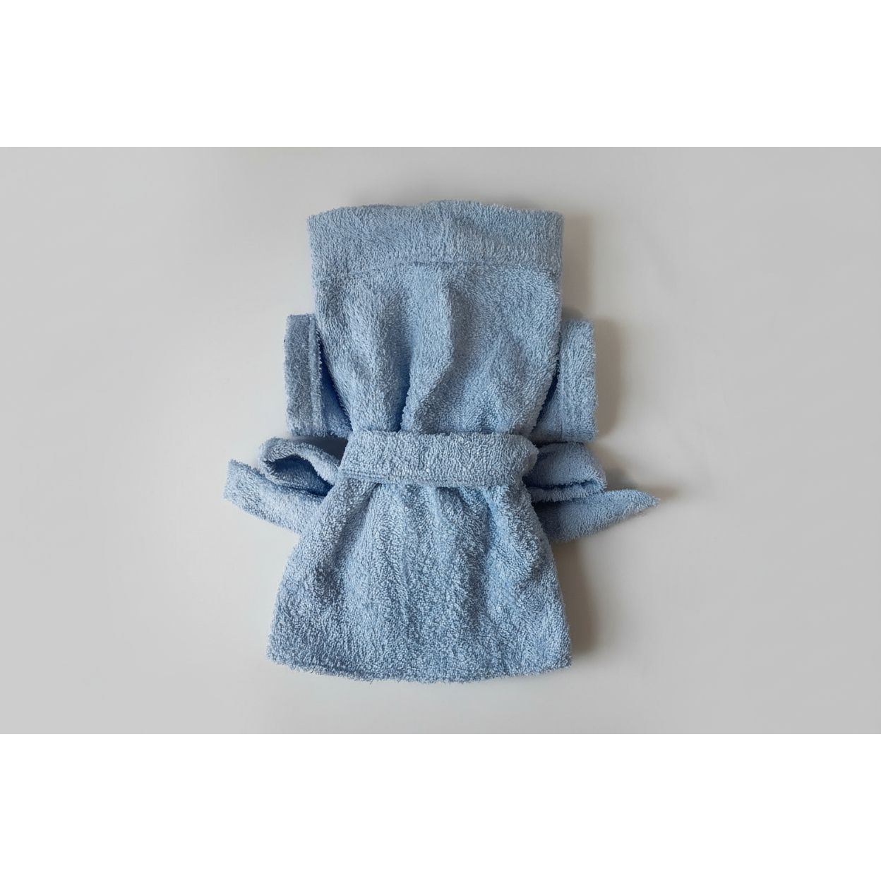 Folded blue robe on a beige surface