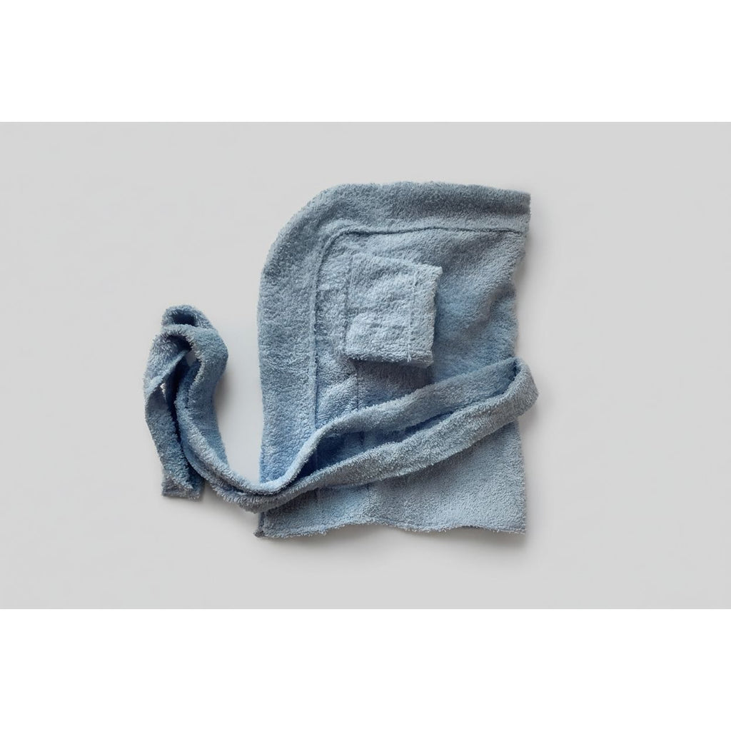 Folded blue dog robe on a beige surface