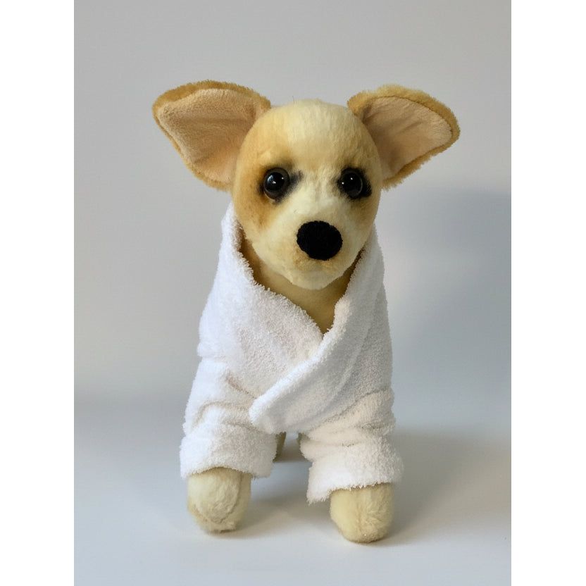 Stuffed dog toy in a white robe on a white background