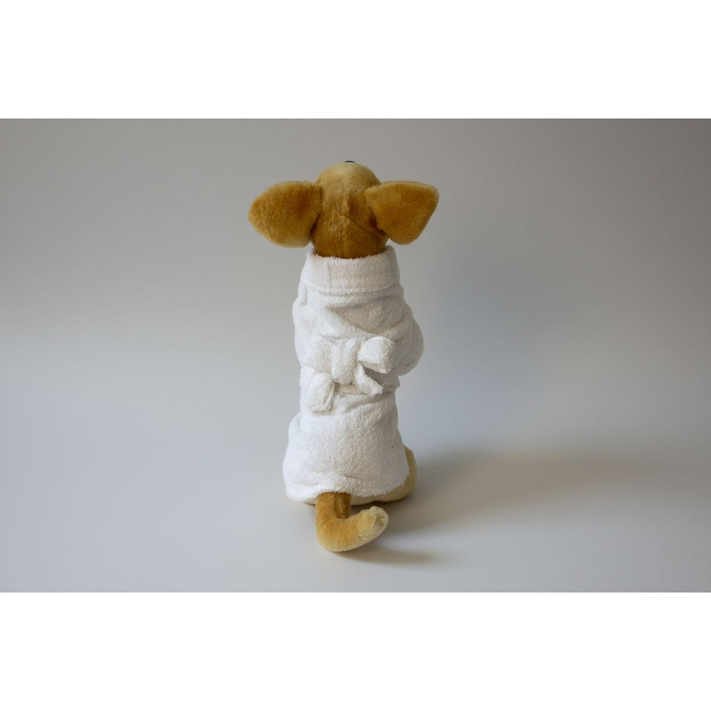 Stuffed dog toy in a white robe on a white background