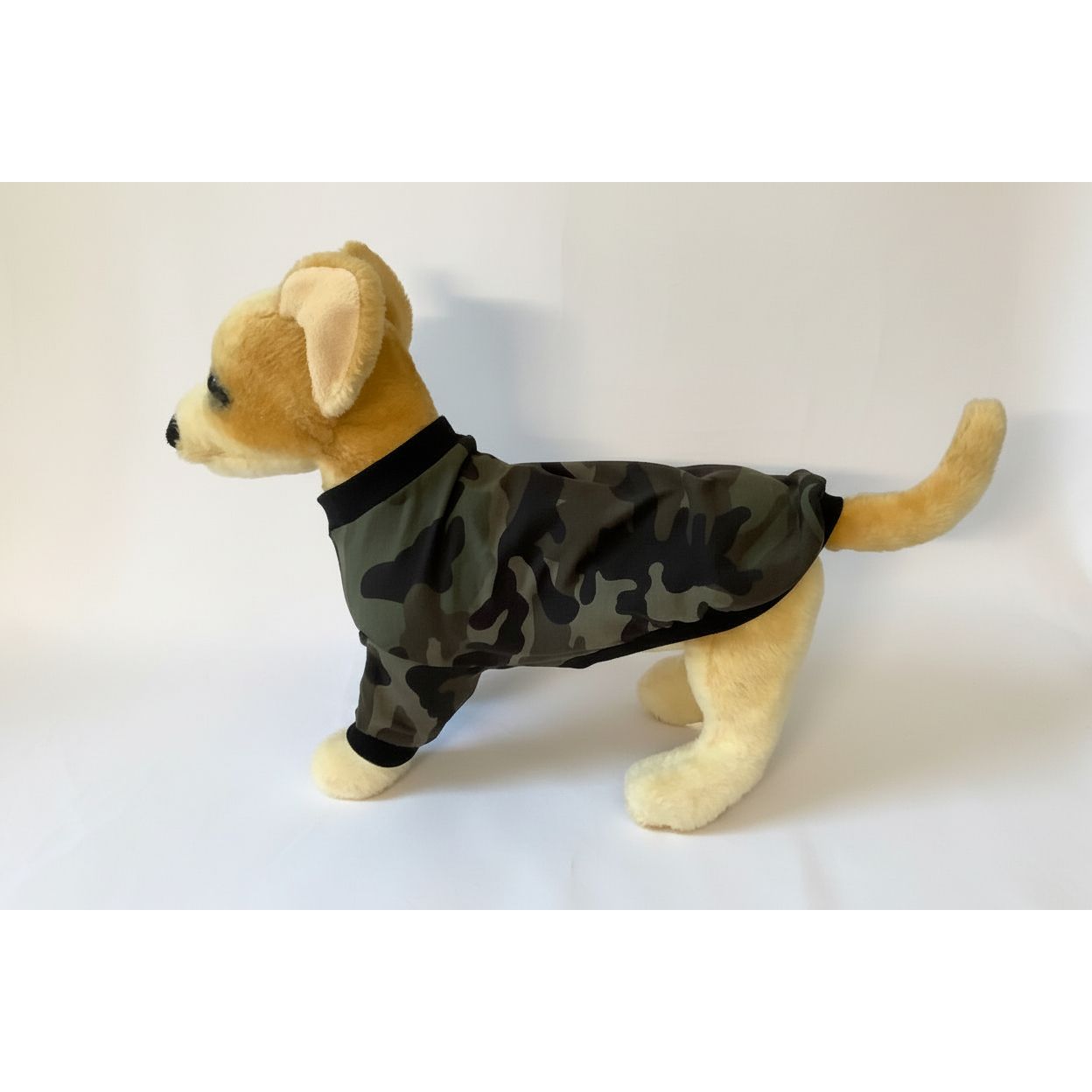 dog wearing a green camo print dog shirt.