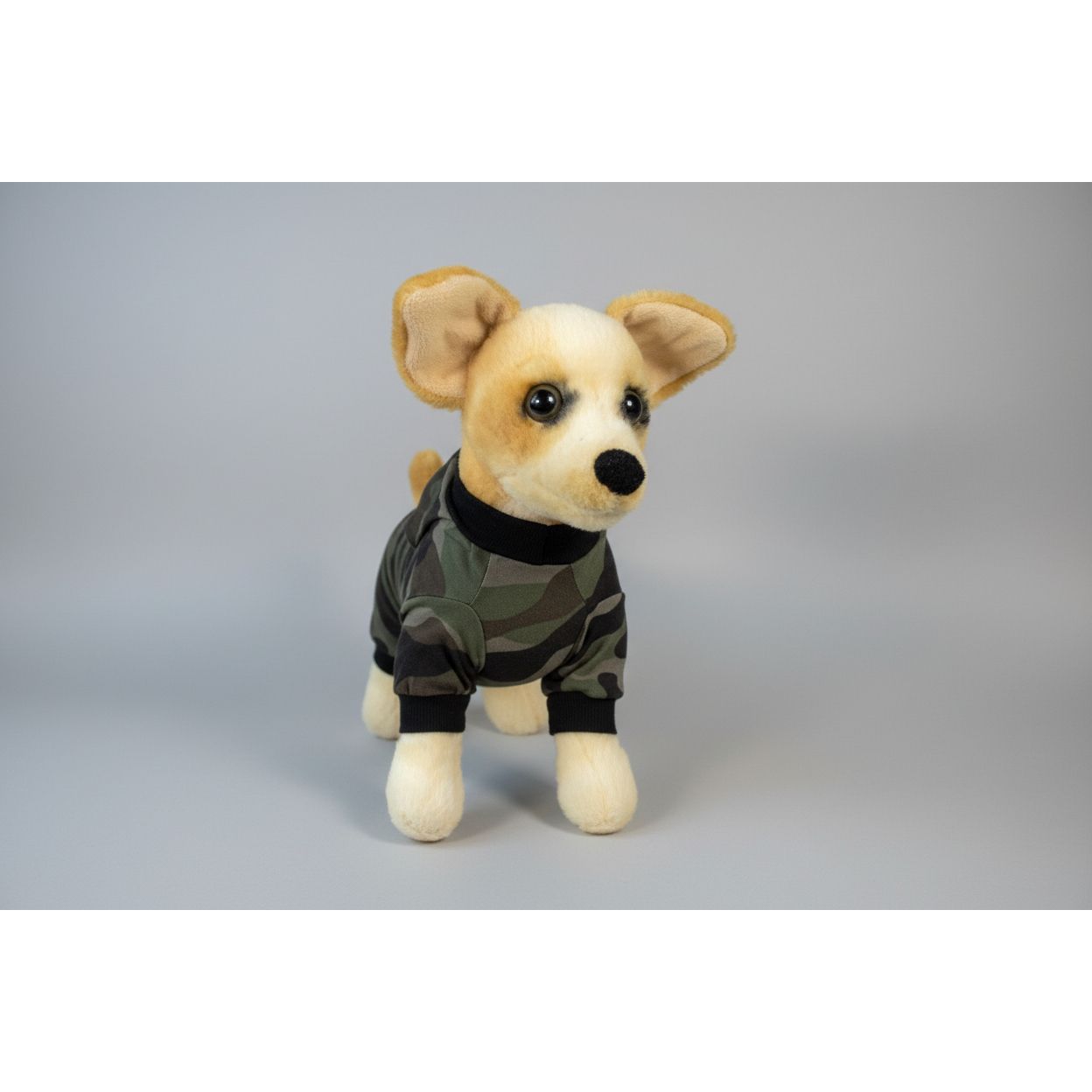 Stuffed dog toy wearing a camouflage outfit on a white background