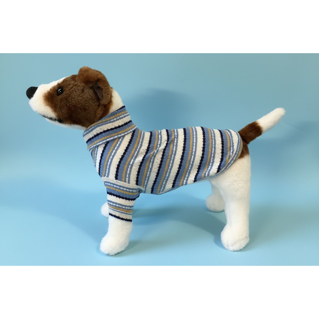 Dog wearing a striped sweater against a white background