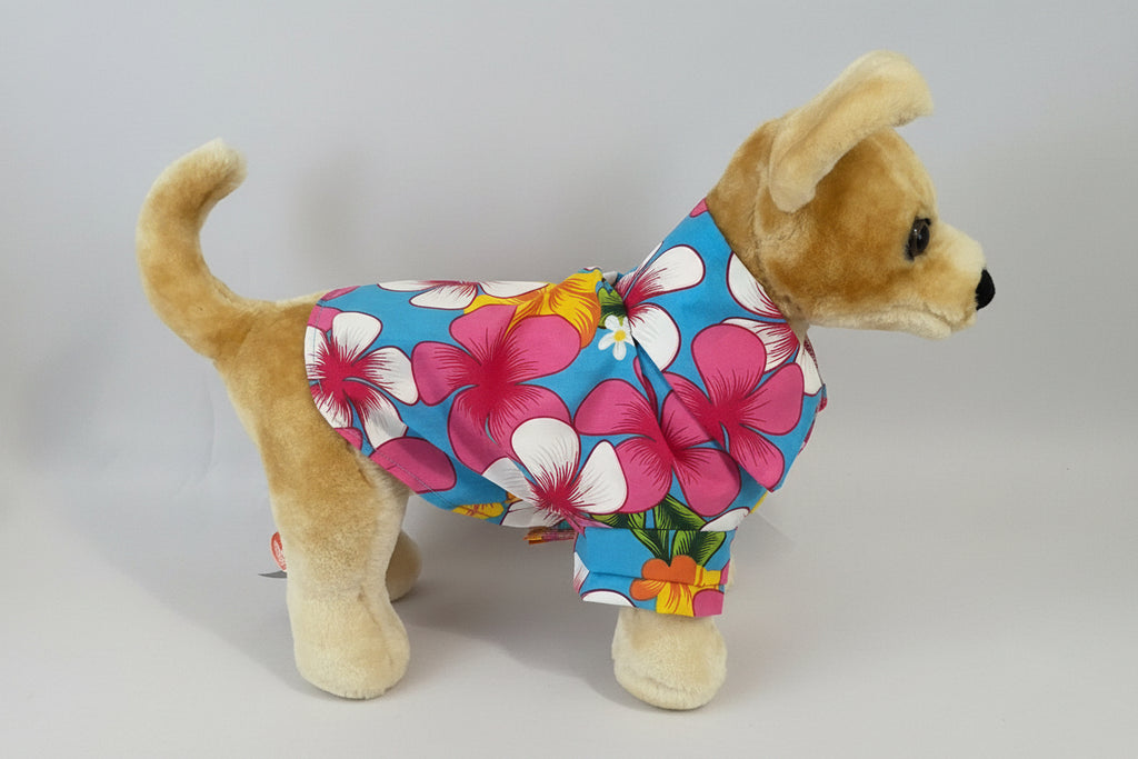 Stuffed dog toy wearing a colorful floral patterned outfit on a gray background