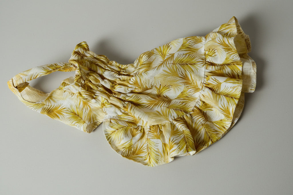 Yellow floral dress on a white fabric background