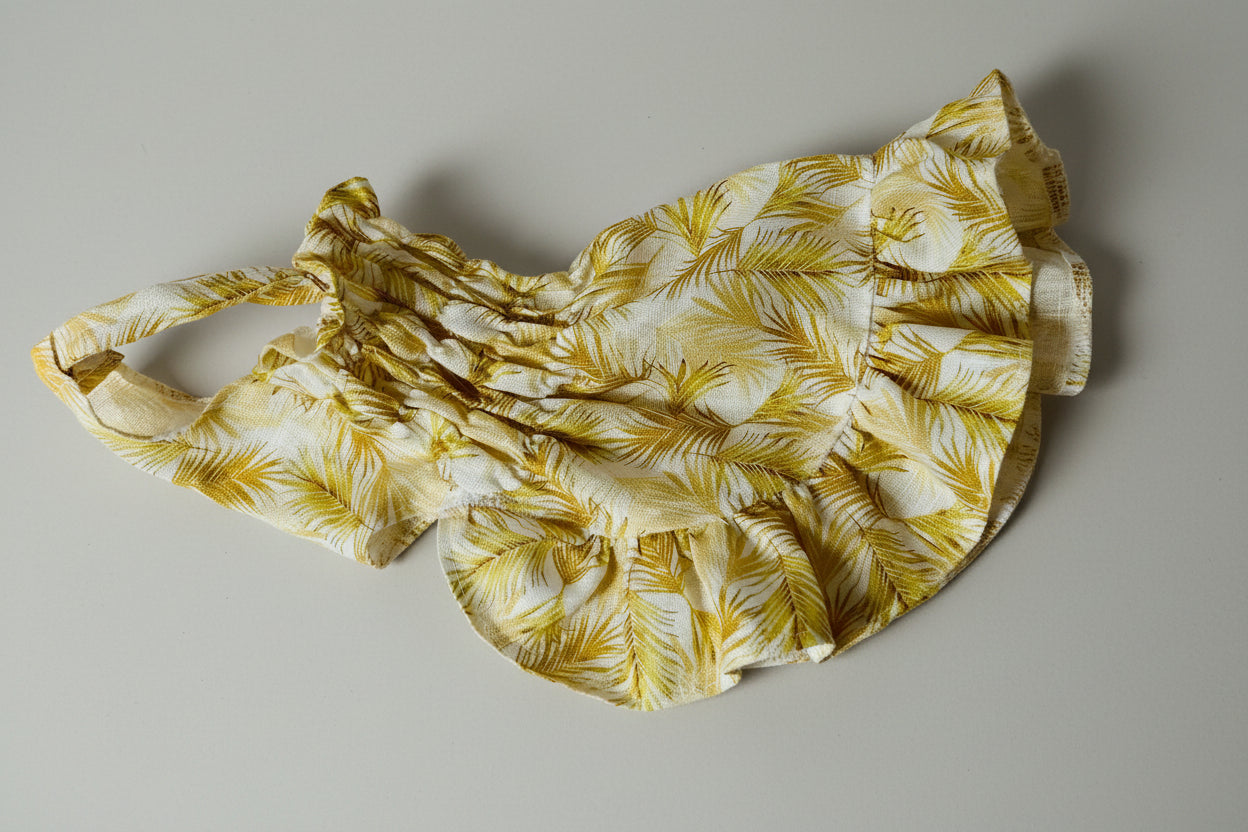 Yellow floral dress on a white fabric background