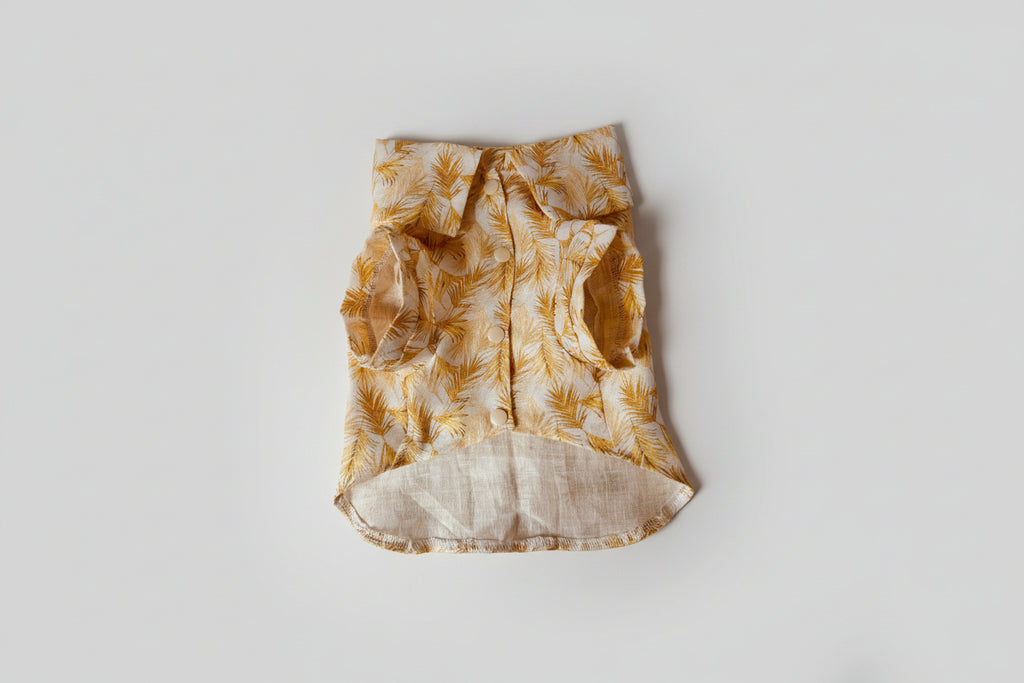 Yellow and beige patterned shirt on a light pink surface