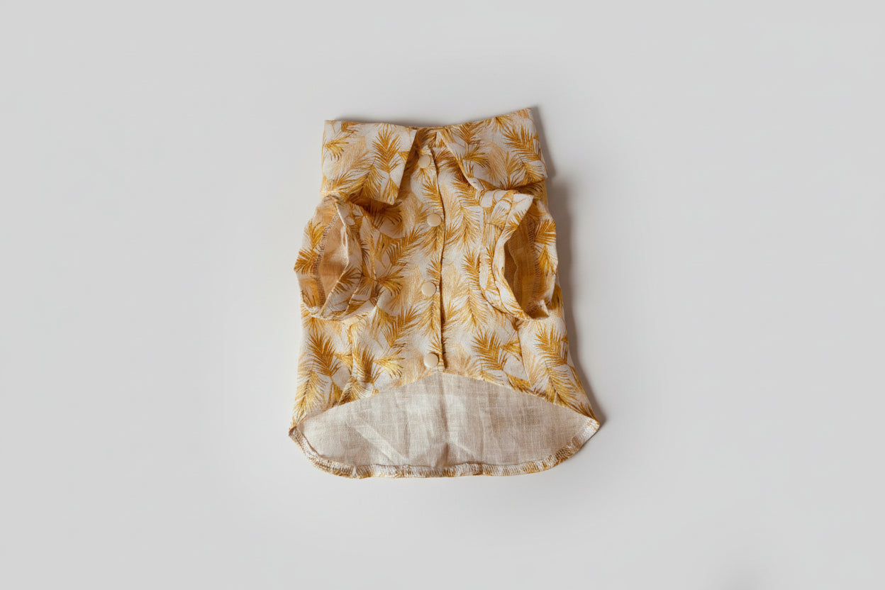 Yellow and beige patterned shirt on a light pink surface