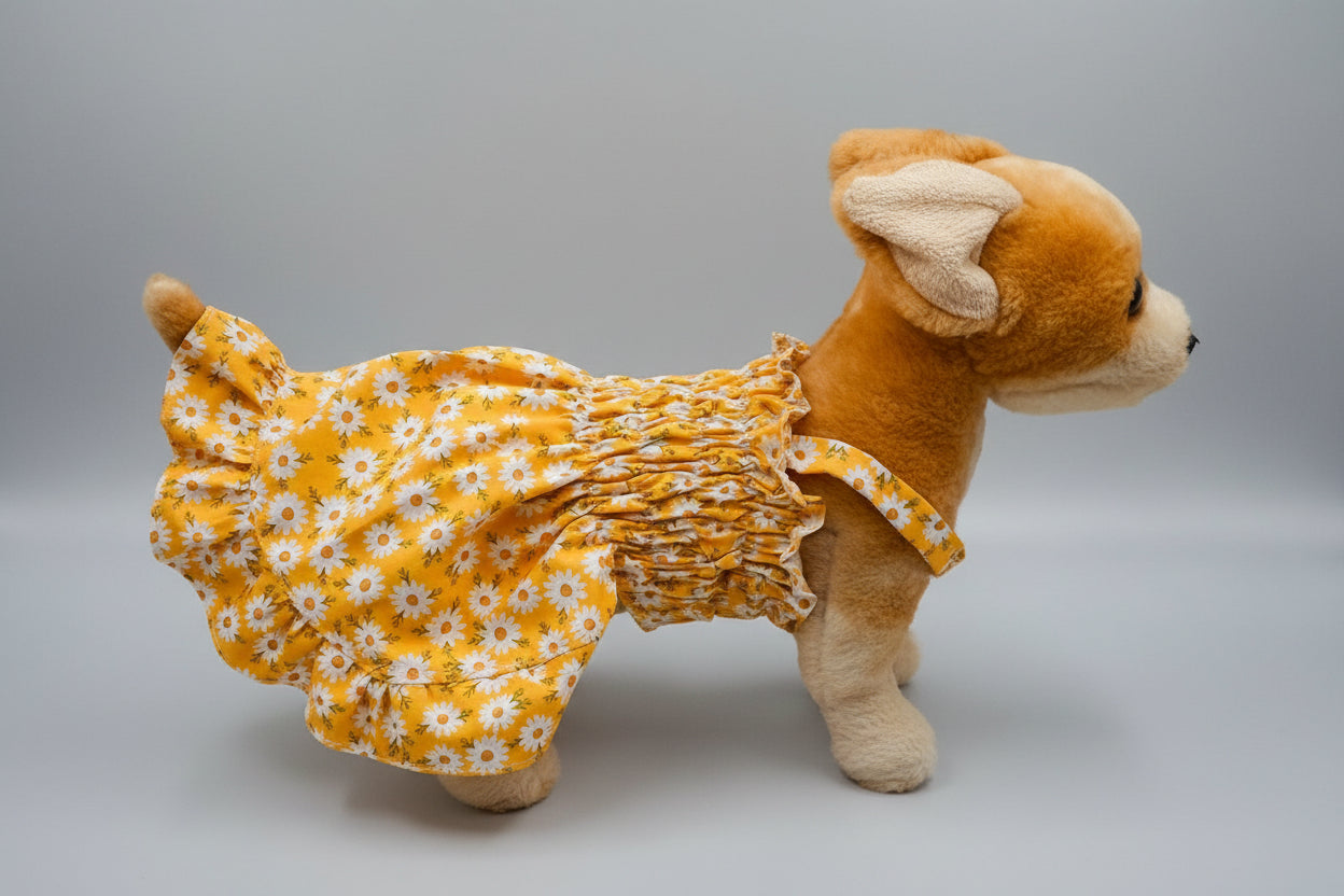 Plush toy dog wearing a yellow floral dress on a white background