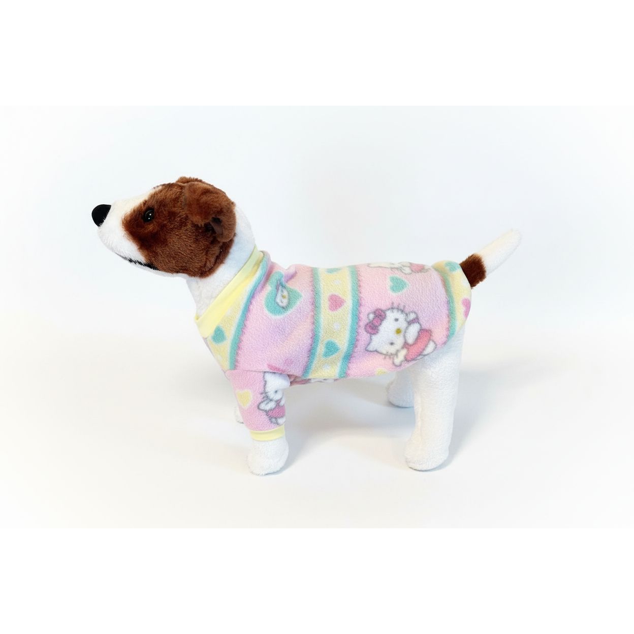 Dog wearing a colorful sweater on a beige couch