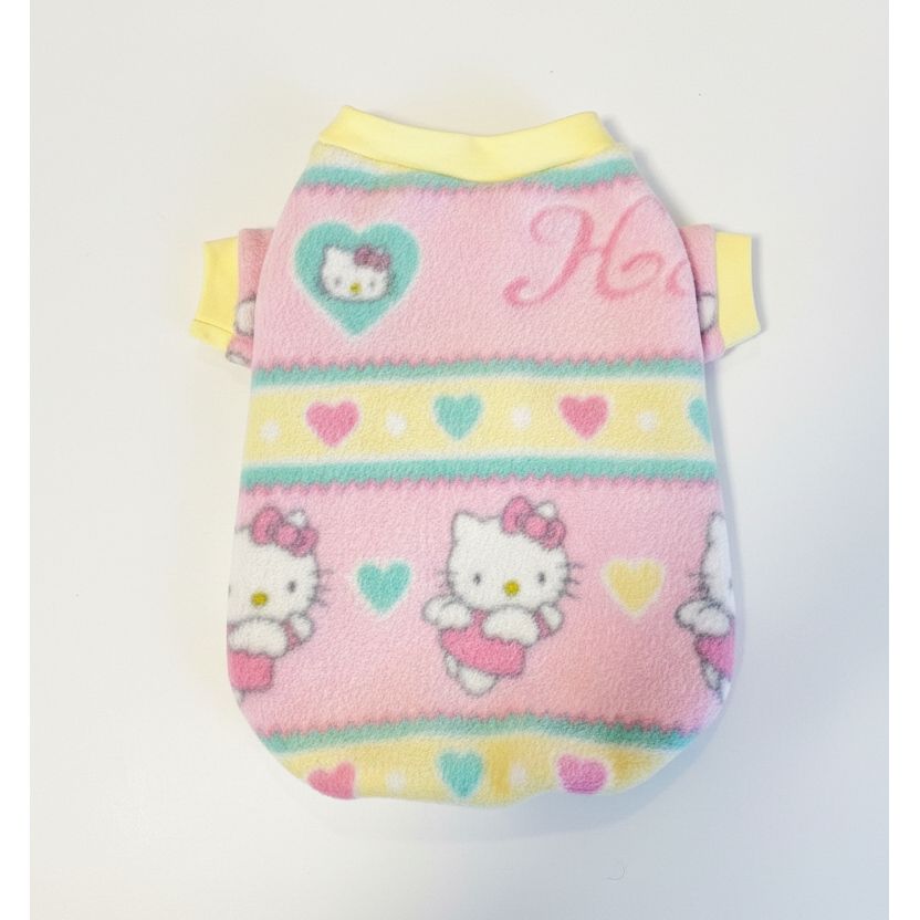 Hello Kitty-themed pink pet sweater on a textured surface