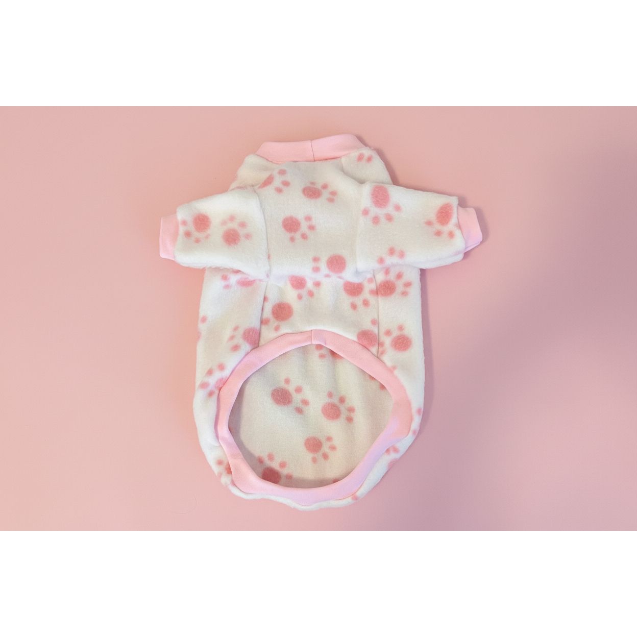 Baby outfit with pink and white design on a beige textured surface