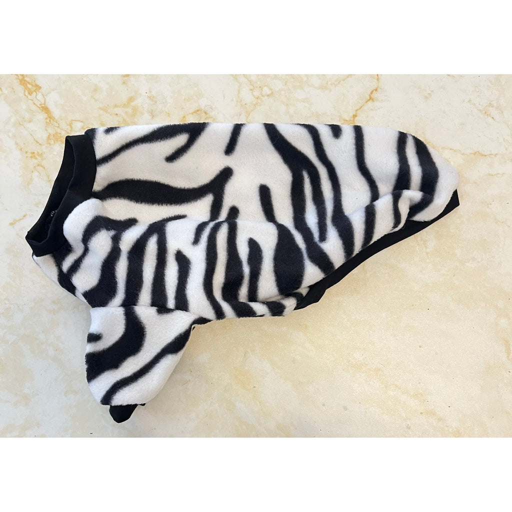 Zebra-patterned dog coat on a beige marble surface