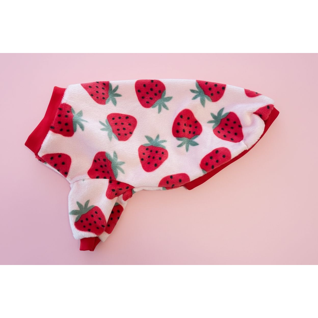Small dog sweater with a red strawberry pattern on a pink background