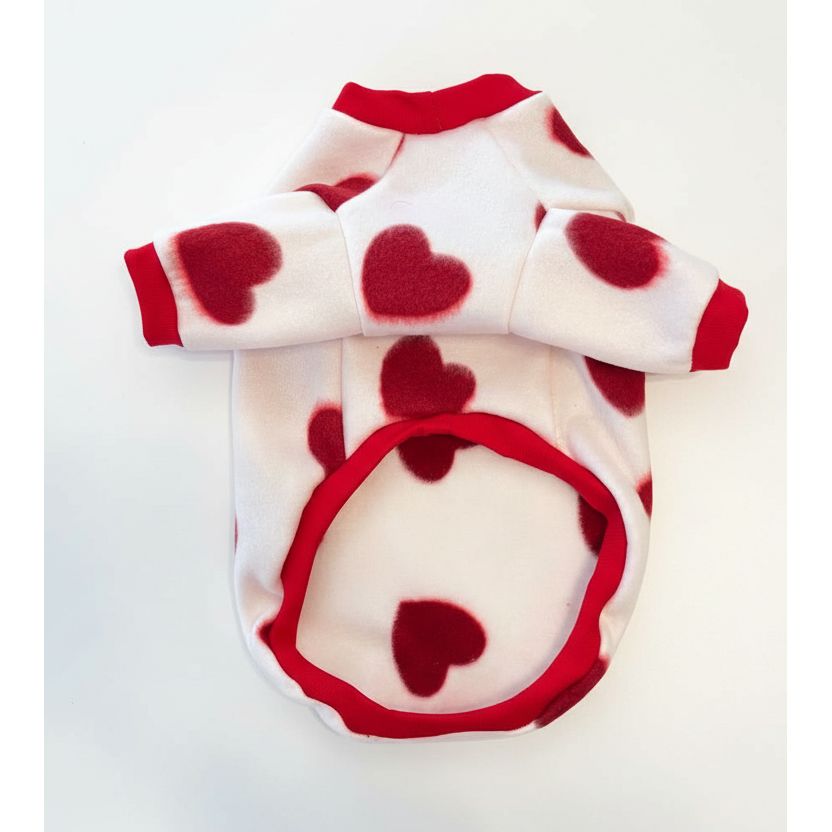 dog sweater with red heart patterns on a beige textured background