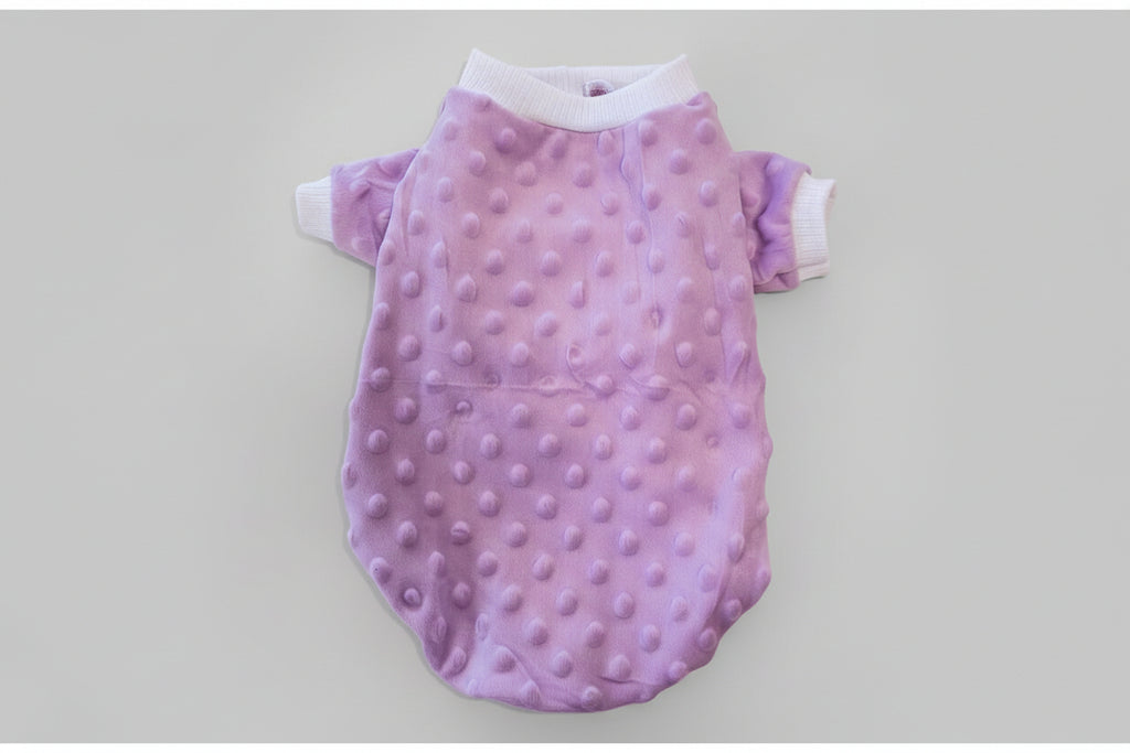 Purple textured baby romper on a pink background
