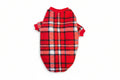 Red plaid dog sweater on a textured beige background