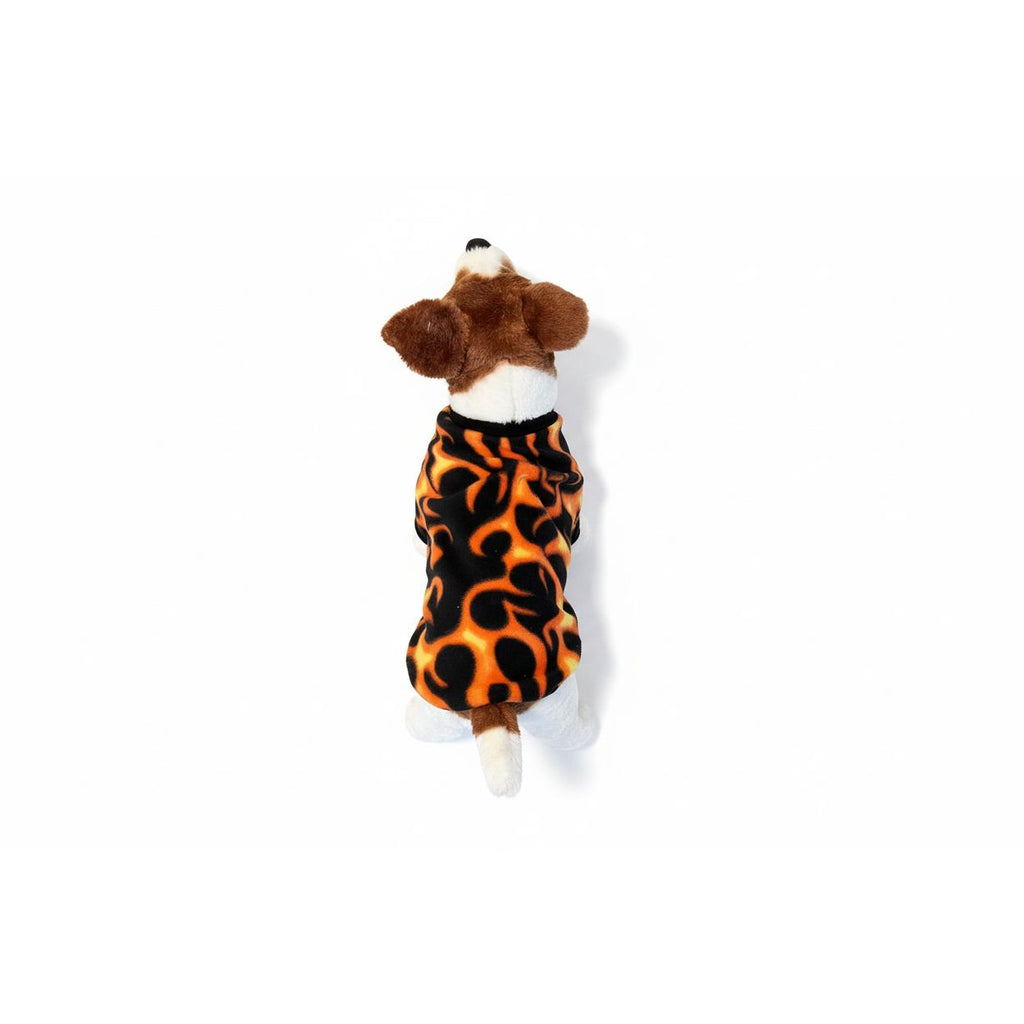 Dog wearing a flames print fleece sweater standing on a beige couch.