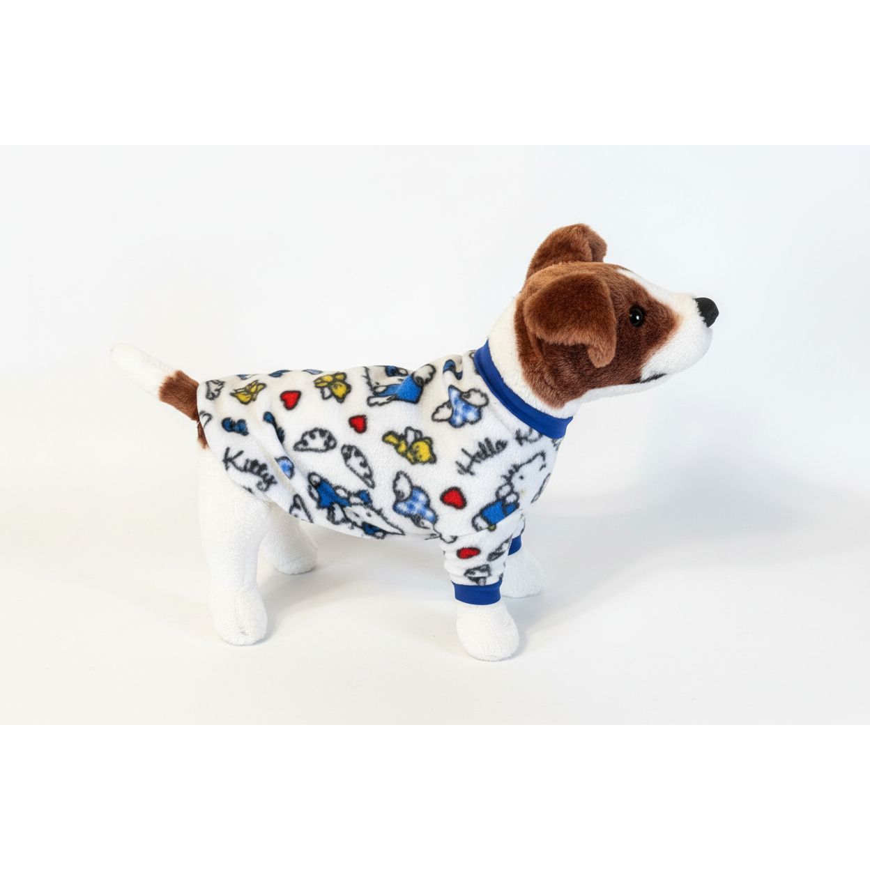 Dog wearing a colorful hello kitty fleece sweater  on a beige couch.