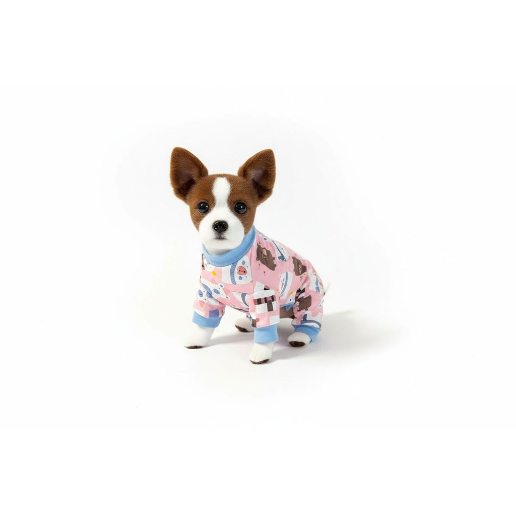 Dog wearing pink pajamas with cartoon designs on a beige couch