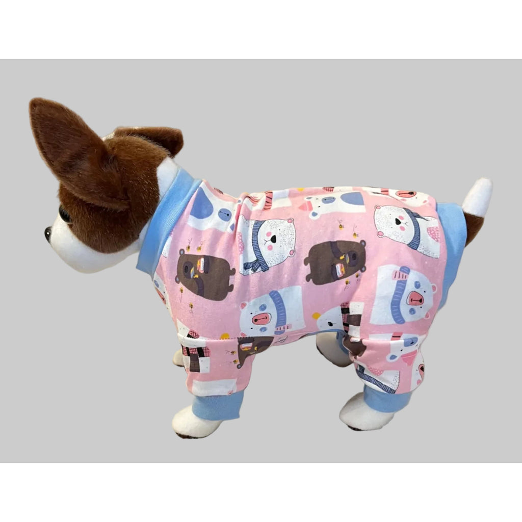 Dog wearing pink pajamas with cartoon dog design on a beige couch