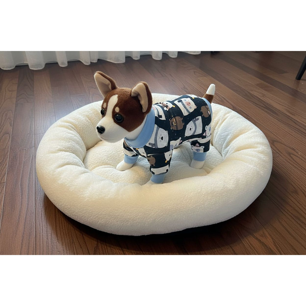 Dog wearing a patterned pajama set on a beige couch