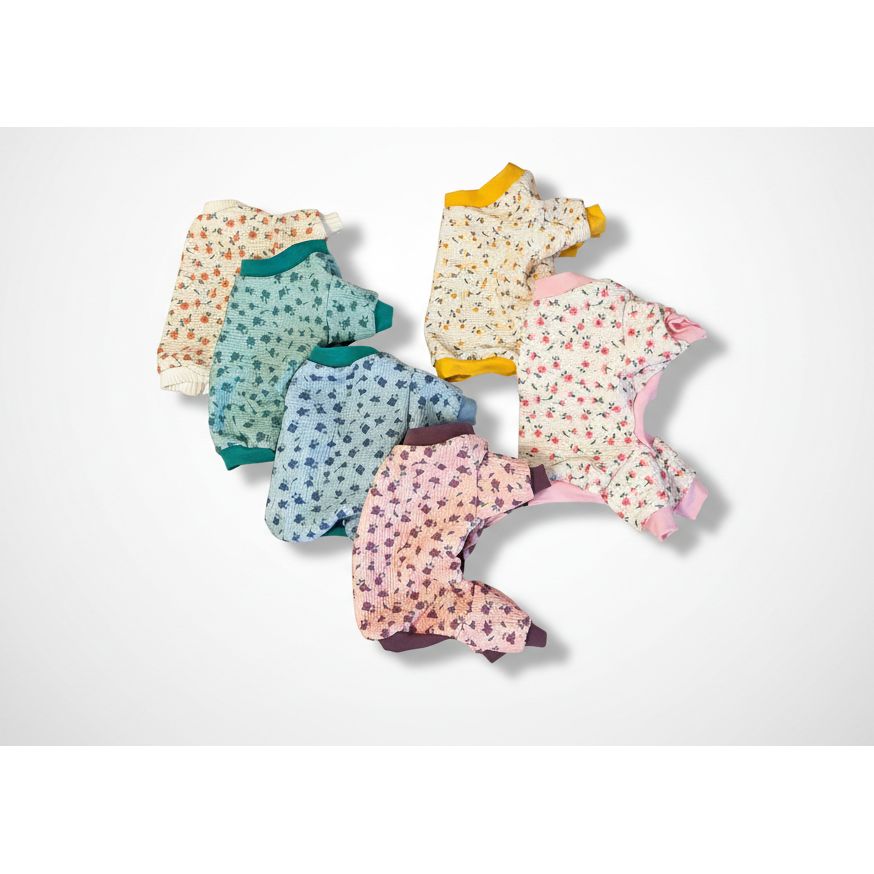 Set of dog pajamas in various patterns on a textured surface