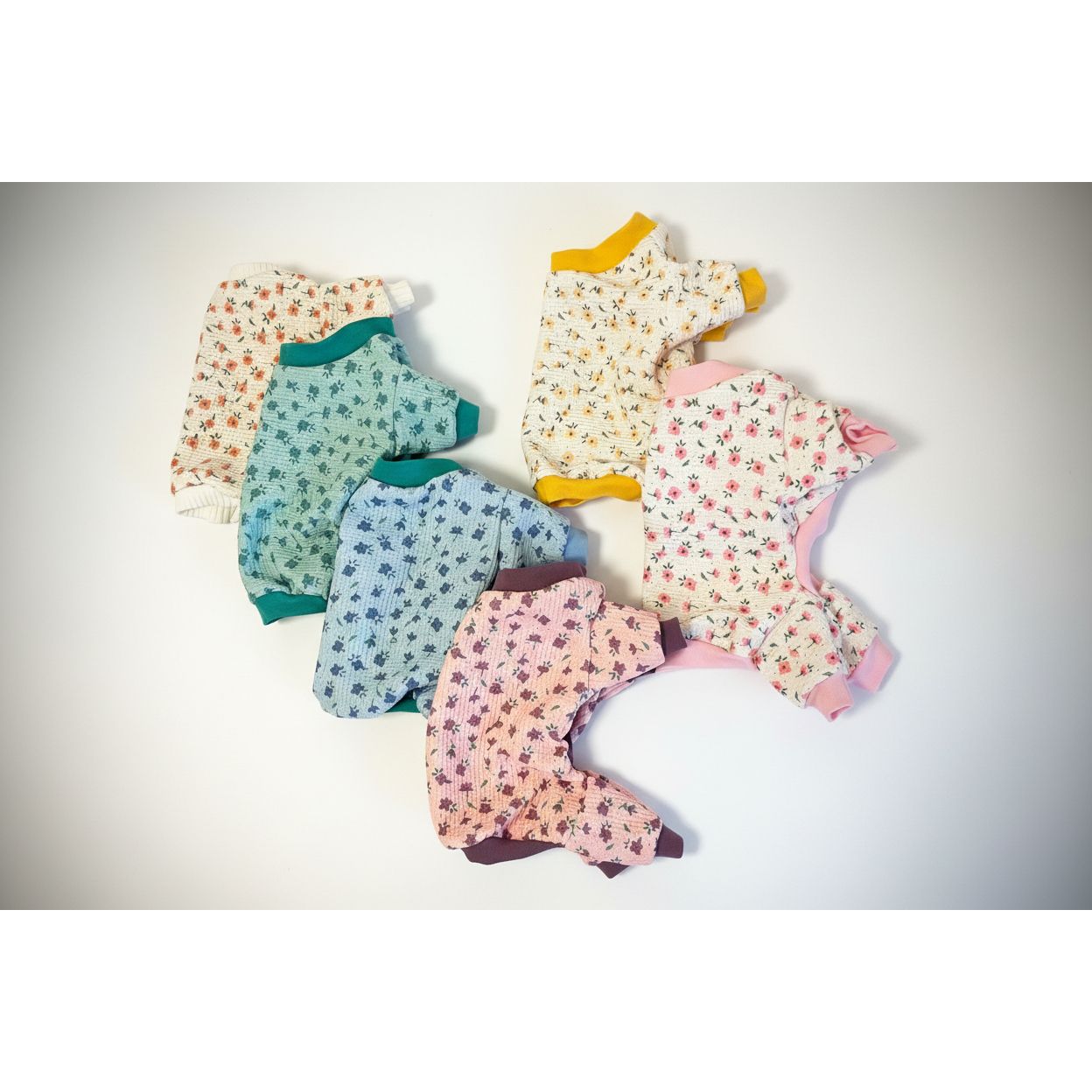 Set of baby rompers in various patterns on a textured surface