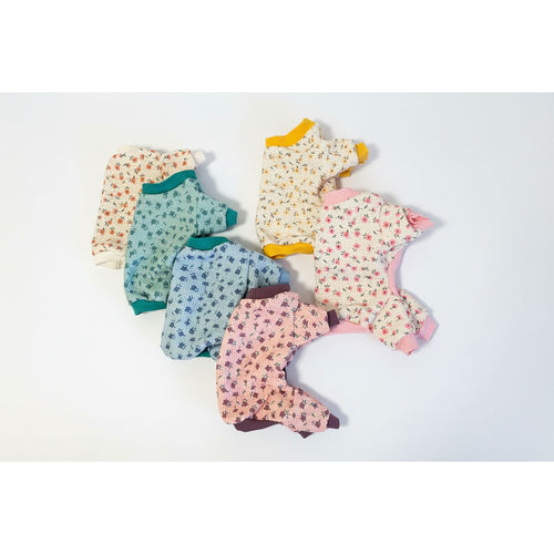 Set of dog pajamas in various patterns on a textured surface
