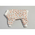 Floral patterned dog pajamas on a beige marble background