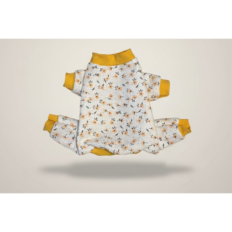 Floral dog outfit with yellow accents on a beige marble surface